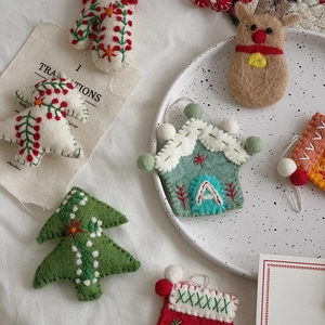 Detailed embroidery on handmade wool felt Christmas ornaments including trees and gloves