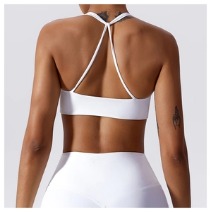 Close-up of white sports bra with criss-cross back straps and high-waisted leggings