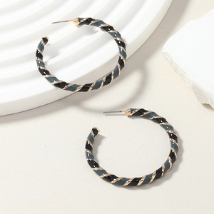 Detail view of large hoop earrings with spiral textures in black gray and golden colors