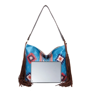 Detail of bohemian woven bag with tassels shown with a tablet for size reference