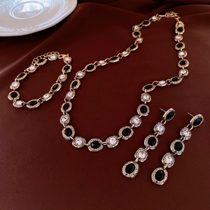 Detailed set of vintage gold necklaces, bracelets, and earrings with black oval stones
