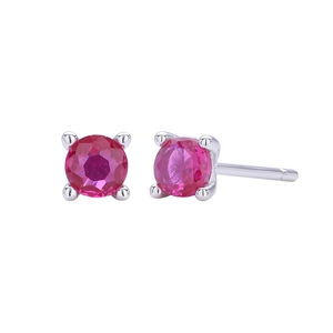 Detail view of round pink ruby stud earrings with classic four-prong silver setting