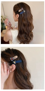 Dettaglio di fermaglio per capelli a fiore blu navy e molletta marmorizzata