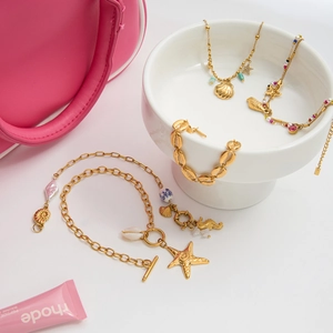 Titanium steel ocean theme bracelet set with seashell and starfish charms in gold finish
