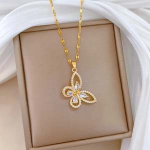 Macro detail of gold butterfly pendant with sparkling zircons on soft silk backdrop