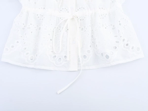 Detail view of white eyelet embroidery blouse with adjustable waist drawstring