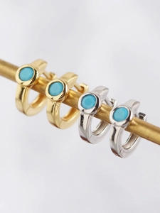 Macro shot of gold and silver hoop earrings featuring centered turquoise stones