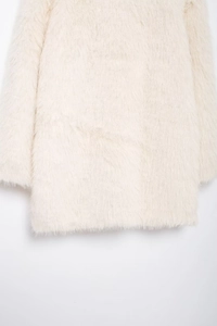 Detailed close-up of white faux fur material on the elegant oversized mid-length coat