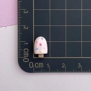 Macro detail of a 1.5cm pink resin ice cream charm for nail art and DIY crafts