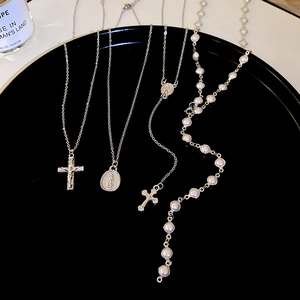 Detailed set of silver Y2K necklaces with cross, Virgin Mary medal, and faux pearls