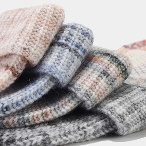 Gros plan sur la texture en maille épaisse et les motifs tie-dye des bonnets d'hiver