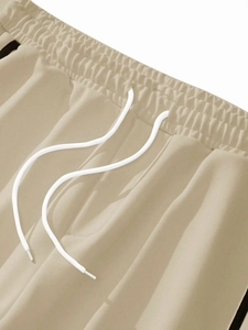 Detailed close-up of beige jogger waistband with white drawstring and elastic fabric