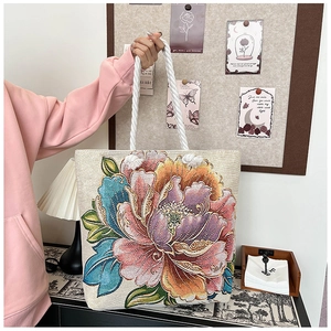 Detail of floral embroidery tote bag featuring thick cotton rope handle and peony pattern