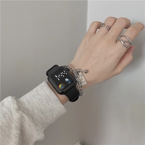 Close-up of black digital sports watch with silver chain bracelet and rings for students