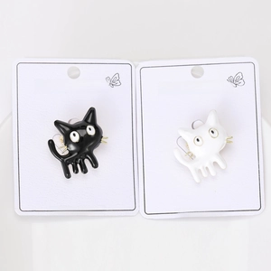 Detail of cute black and white enamel cat brooches on branded fashion jewelry cards