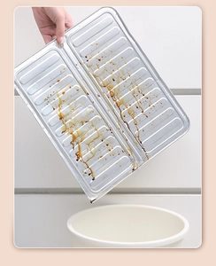 Disposal of a used corrugated aluminum foil tray with oil stains into a white trash bin