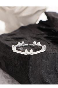 Detail showing S925 hallmark on polished silver bow ring with elegant metal texture