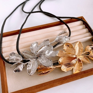 Detailed view of large vintage metal tulip flower pendants with black leather cords