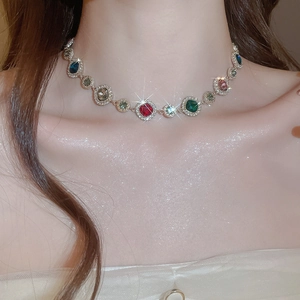 Nahaufnahme einer eleganten Goldhalskette mit bunten Edelsteinen und Glitzereffekt