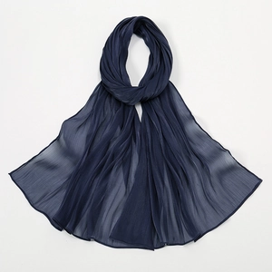 Detail eines marineblauen Chiffon-Schals mit feiner Faltenstruktur und Transparenz