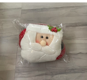 Close-up detail of plush Santa Claus Christmas tree topper hat decoration in clear packaging