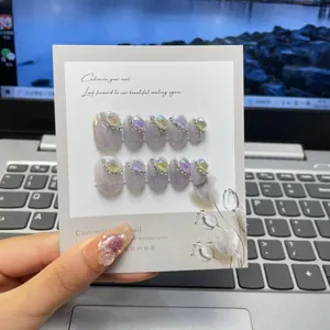 Macro detail of lavender glitter fake nails with rhinestones and square gems