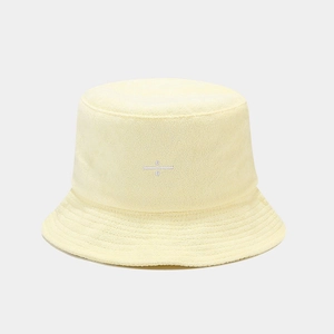 Macro detail of terry cloth texture and white embroidered logo on a yellow bucket hat