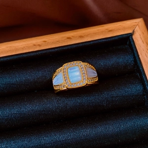 Macro shot of a vintage gold ring with mother-of-pearl inlay and pavé crystals