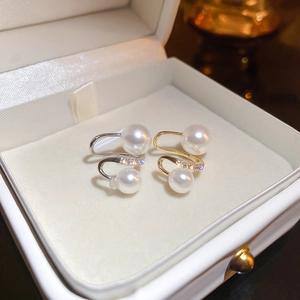 Detail of twisted S-curve ear clips featuring pearls and micro-set cubic zirconia stones