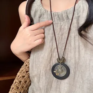 Bohemian wood bead necklace with circular pendant and vintage metallic details