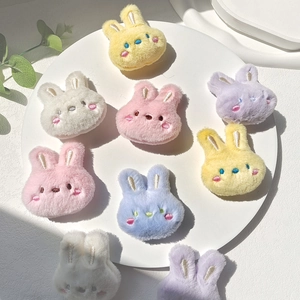 Colorful plush bunny doll brooches in candy colors on a decorative white tray