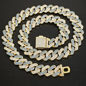 Macro shot of gold Cuban link necklace with alternating blue and clear inlaid crystals