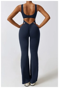 Detail view of navy yoga jumpsuit featuring an open back design and flare leg style