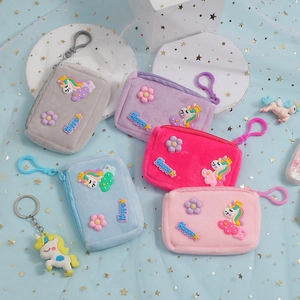 Macro shot of colorful plush unicorn coin purses with Happy embroidery and clip
