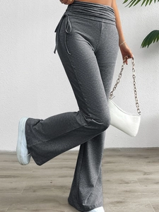 Détail du pantalon évasé taille haute avec cordon de serrage latéral et plis