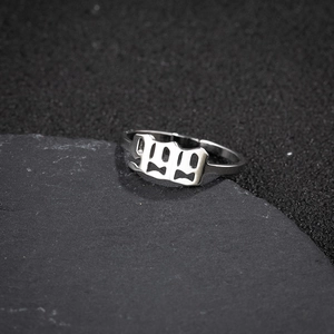 Macro shot of silver stainless steel adjustable ring featuring gothic 1999 number detail