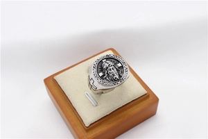 Macro shot of retro steel ring featuring Jesus Christ relief and side cross engraving