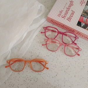 Kids trendy color-changing sunglasses in orange and pink frames on stone texture