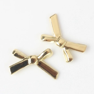 Close-up of elegant gold metal bow-knot earrings on a clean white background