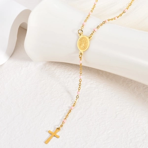 Dettaglio del rosario in acciaio placcato oro 18K con perline rosa e medaglia della Madonna