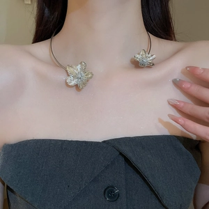 Detail of silver metallic floral choker necklace on a model showing refined design