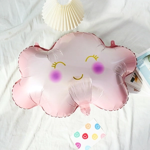 Detailed close-up of a pink smiling cloud foil balloon on a white decorative backdrop