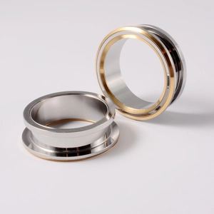Close-up of dual-tone silver and gold stainless steel ear gauges with polished finish
