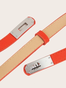 Detailed view of an orange adjustable slim belt featuring a silver Kelly-style metal buckle