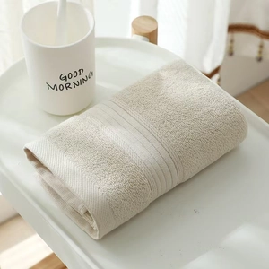 Close-up of thick beige long-staple cotton towel neatly folded on a minimalist tabletop