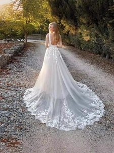 Detail view of white lace floral embroidery on a long tulle wedding dress train