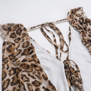 Detail shot of leopard print mini dress featuring ruffled edges and thin tie-up straps
