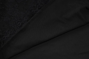 Detailaufnahme der schwarzen Spitzen-Netznähte am langärmligen figurbetonten Minikleid