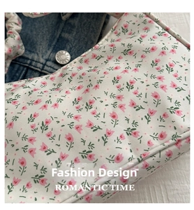 Detail of floral tulip print fabric and pleated handle on canvas shoulder bag