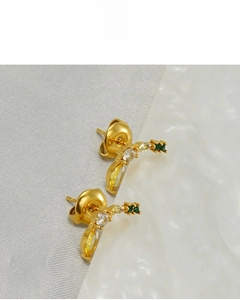 Détail de boucles d'oreilles banane plaquées or 18 carats avec cristaux colorés